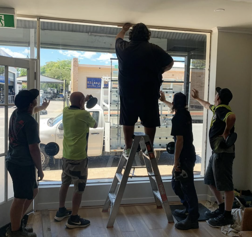 Glaziers working on a glass shop front in Adelaide